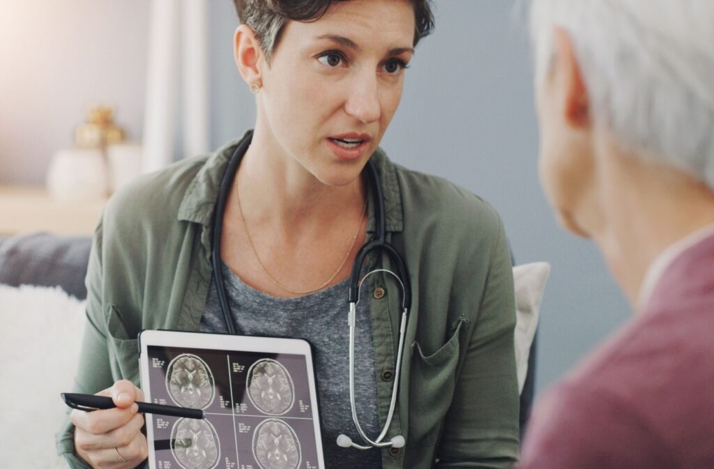 A medical professional pointing to a brain scan while explaining to a patient that the patient is experiencing signs of cognitive decline.