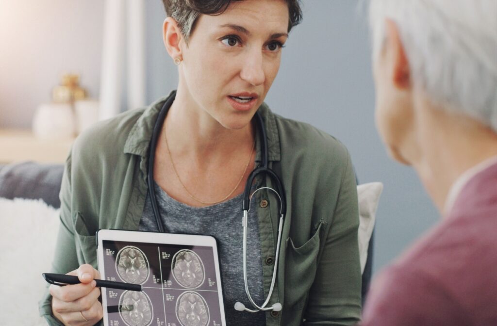 A medical professional pointing to a brain scan while explaining to a patient that the patient is experiencing signs of cognitive decline.