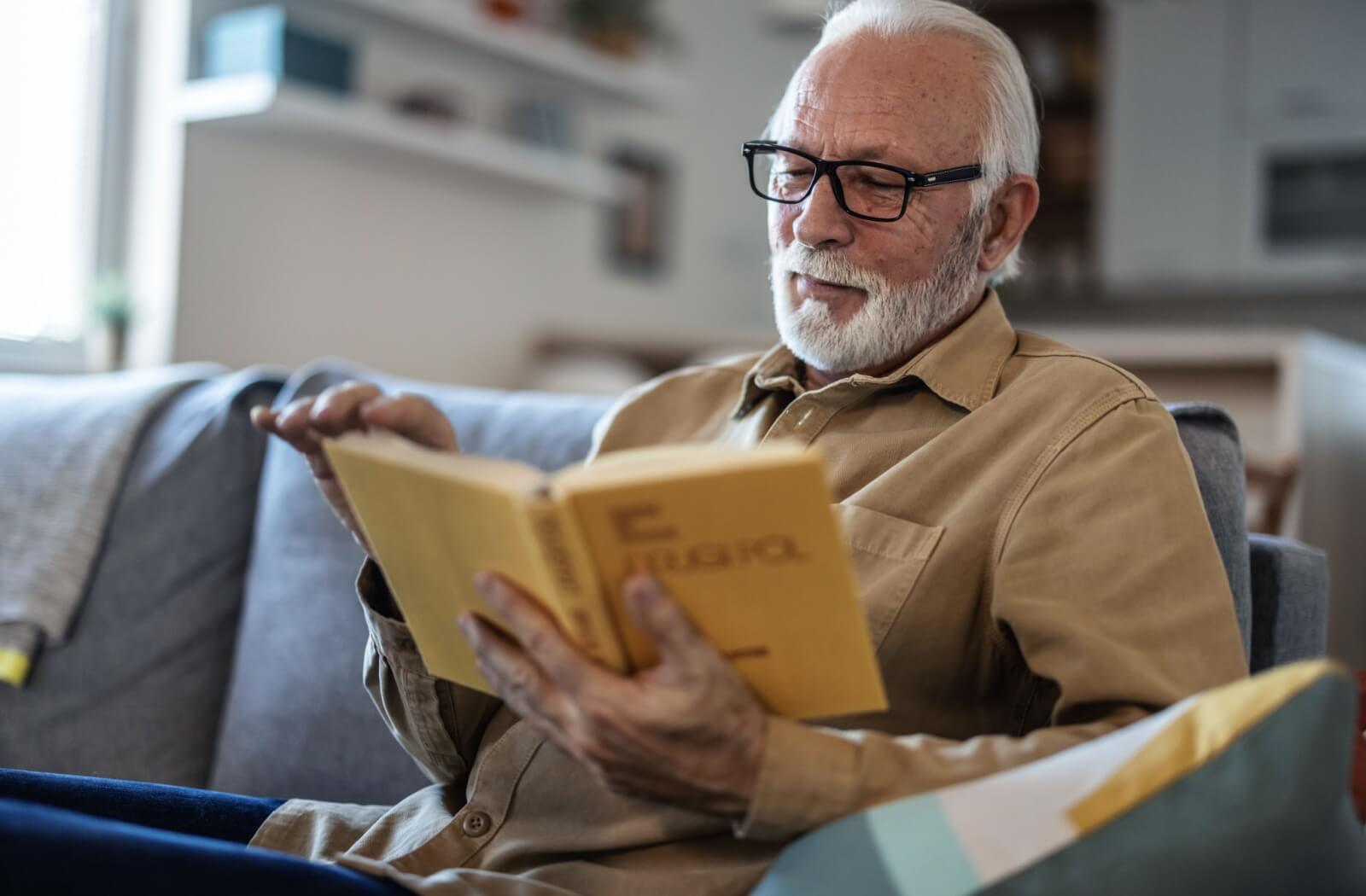 Someone reads a book, happily passing time working on their cognitive abilities.