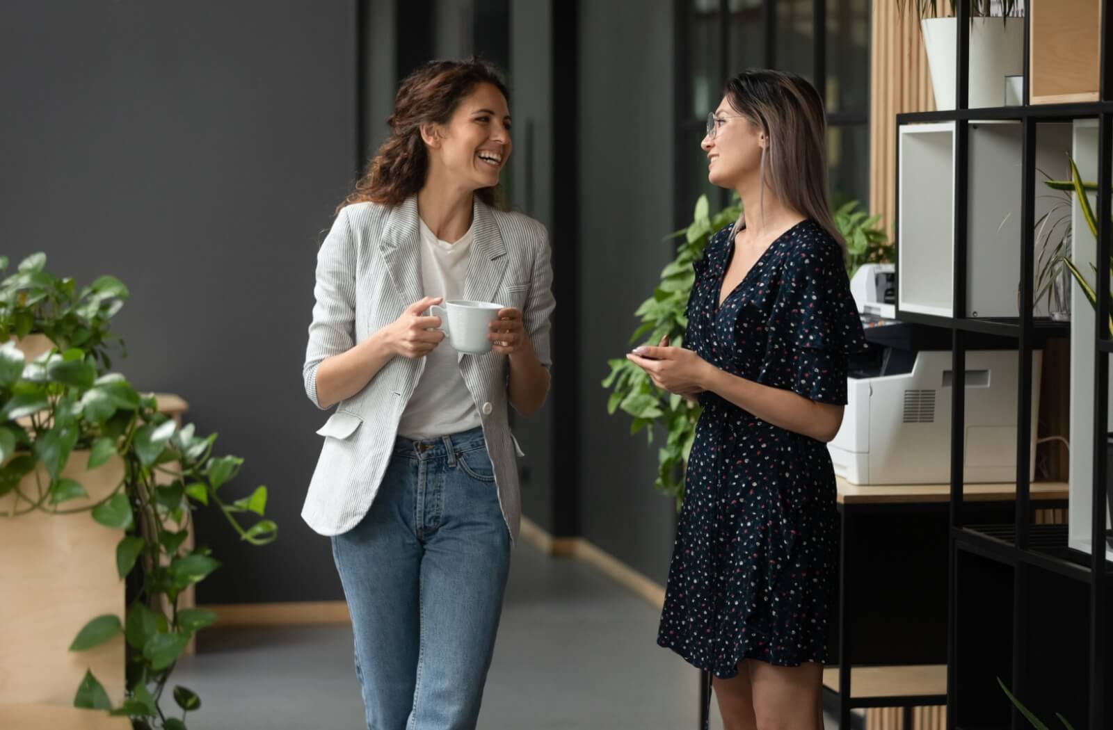 A couple of friends enjoy chatting together casually at work to help destress.