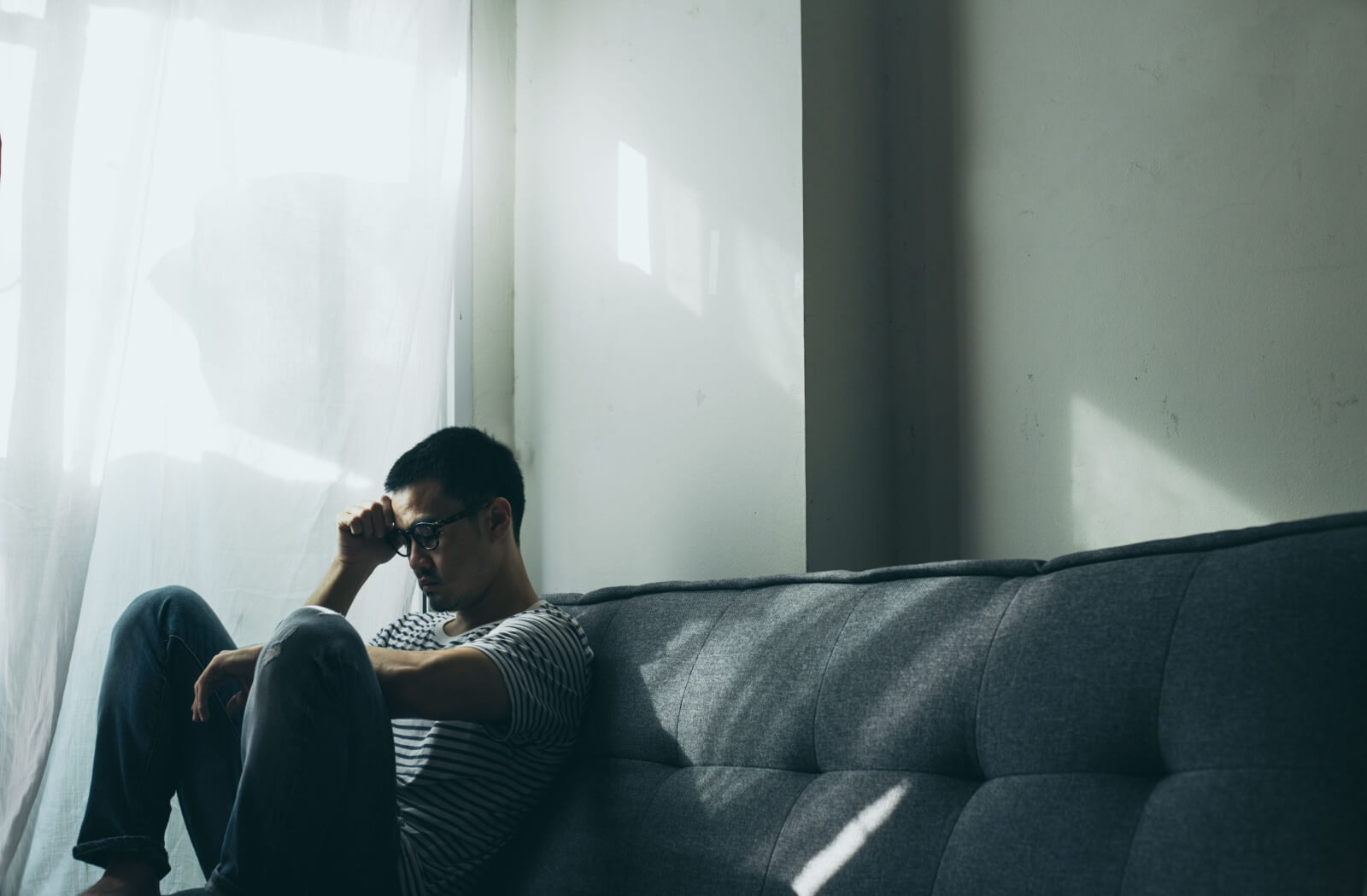 A stressed-out caregiver sits alone in the dark.