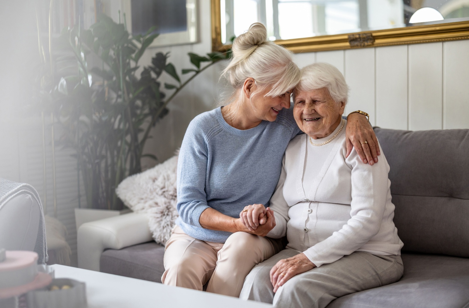 A smiling senior with dementia sits with their adult child in memory care after going through the FAST Scale.