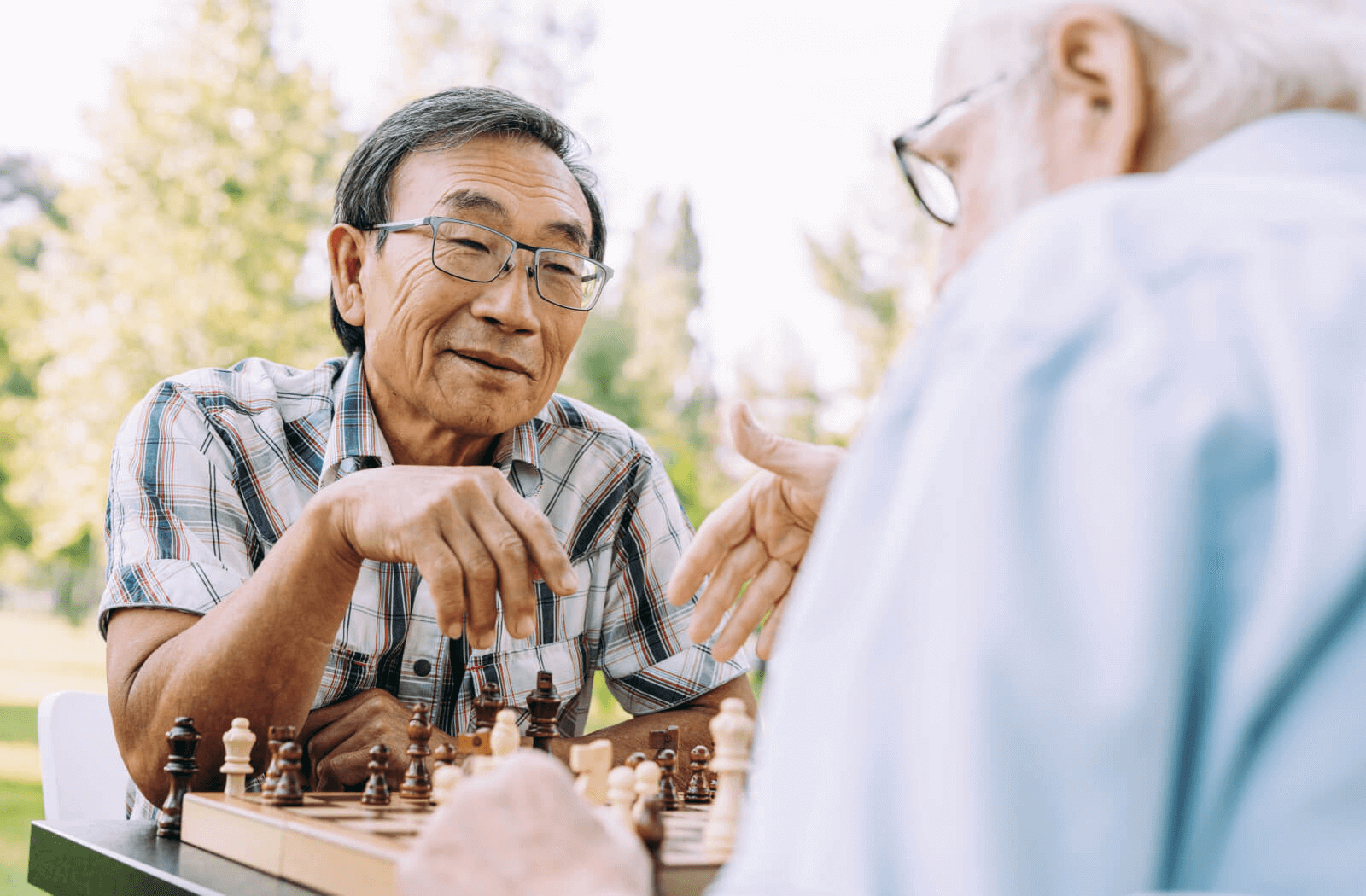 two seniors play chess in the park