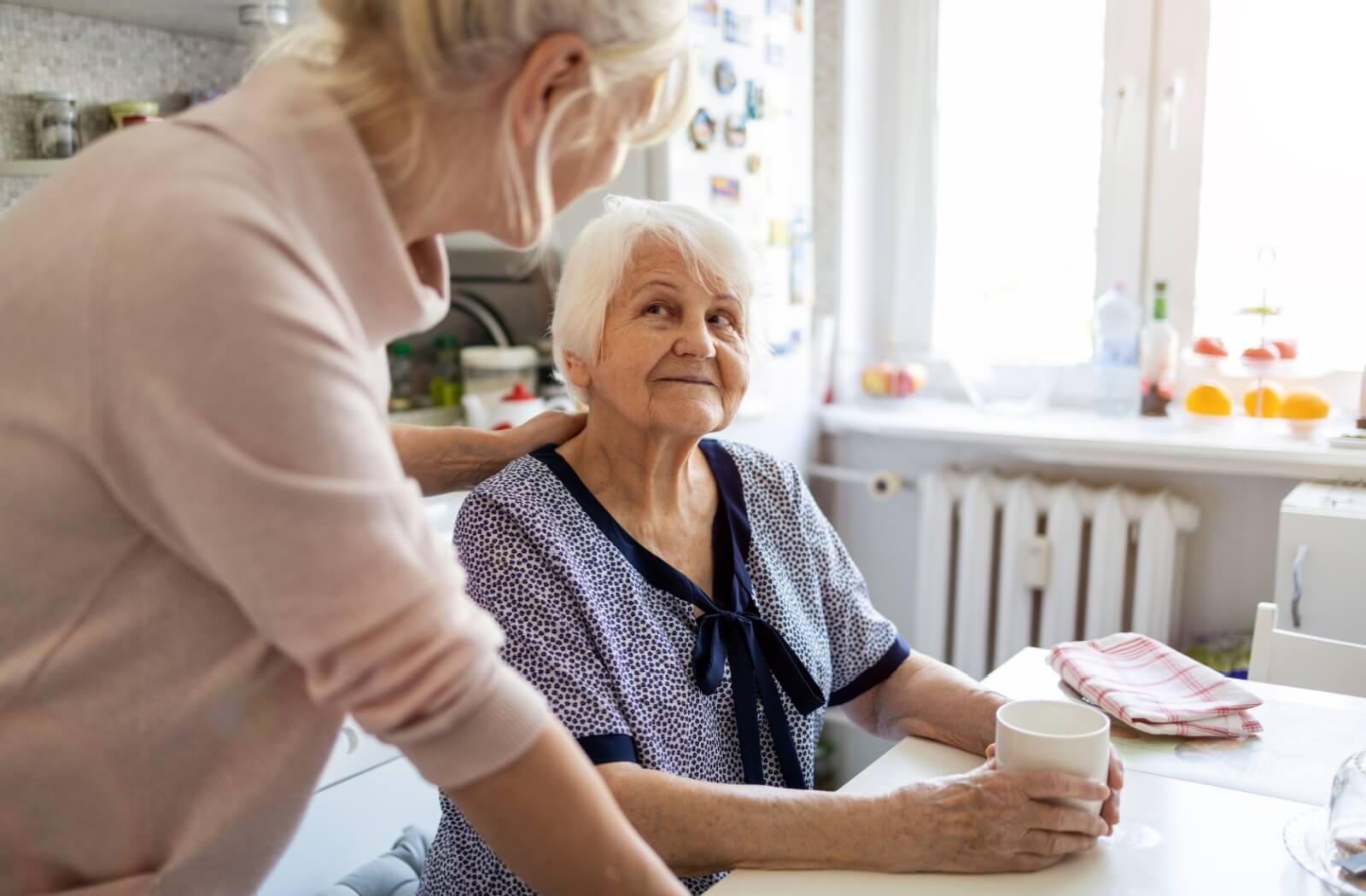 a senior being served at a table by a carer